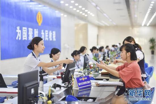  國家稅務(wù)總局泉州市稅務(wù)局豐澤街辦稅服務(wù)廳的工作人員在新辦企業(yè)服務(wù)窗口為納稅人提供“套餐式”服務(wù)（2018年9月13日攝）,。新華社記者 宋為偉 攝