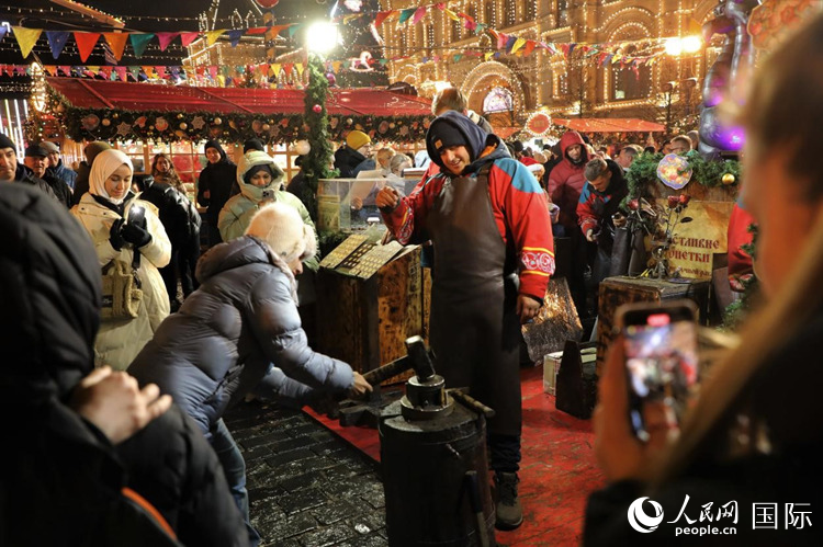 游客在新年集市上體驗制作紀(jì)念幣,。人民網(wǎng)記者 隋鑫攝